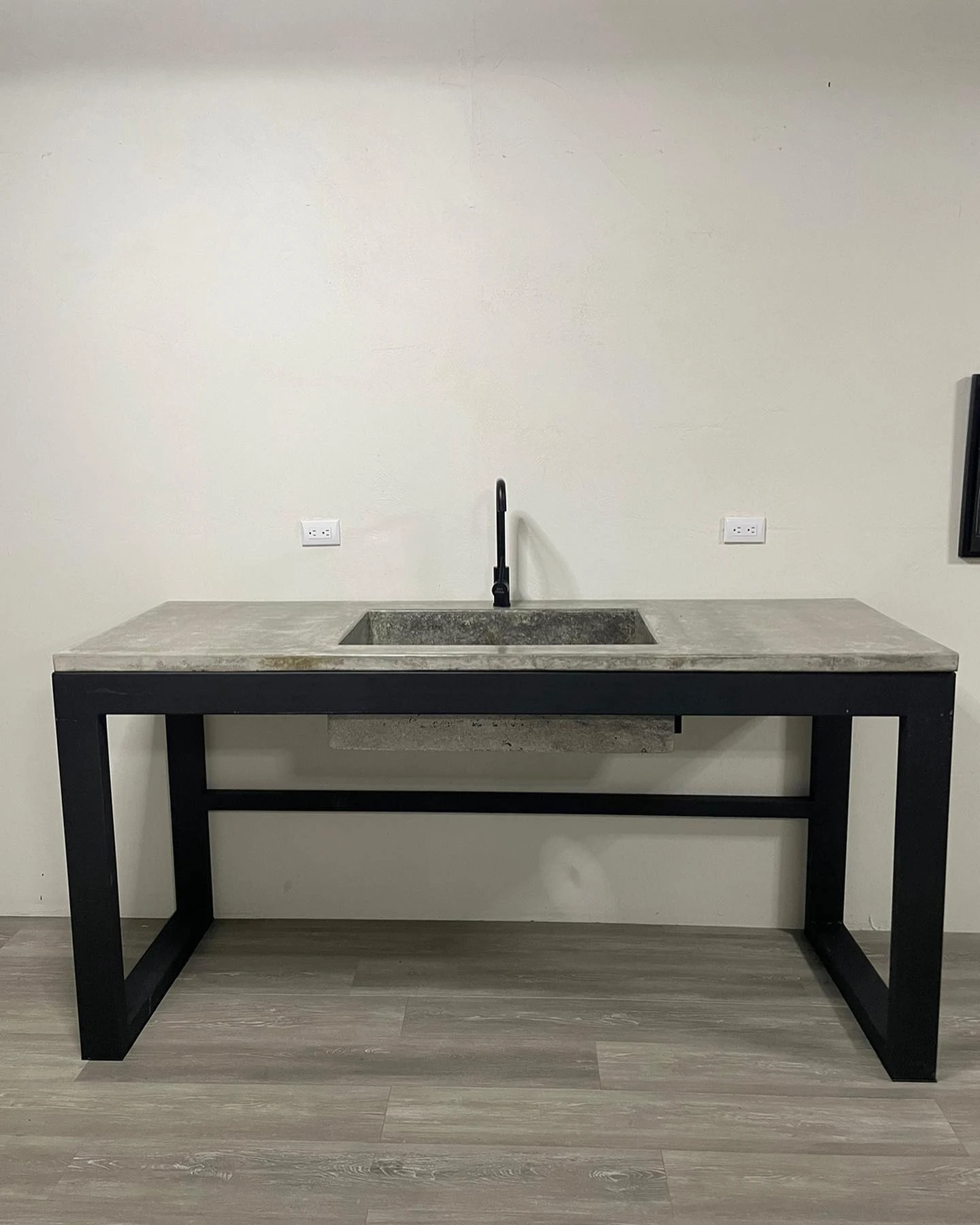 Pila de concreto gris con poza rectangular rehundida y escurridero, sobre estructura de metal negro